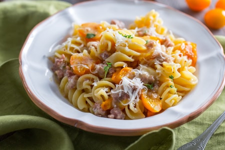 Fusilloni with sausage, yellow cherry tomatoes, and provolone