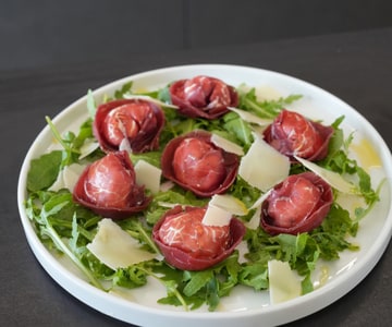 Bresaola Tortelli Stuffed with Ricotta on a bed of Arugula