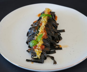 Squid Ink Tagliolini with Anchovies, Cherry Tomatoes, and Candied Lemon