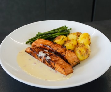 Marinated salmon with sautéed potatoes, green beans, and pink peppercorn sauce